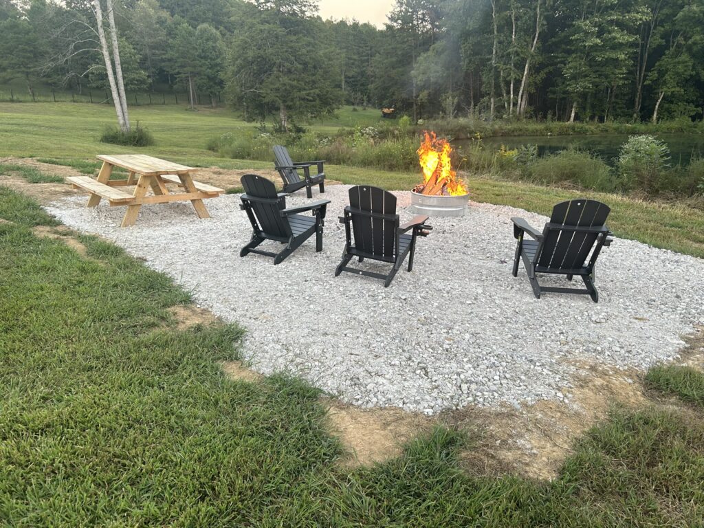 Firepit and picnic tables relaxing by pond at airbnb rental cabin near Wildcat Off-Road Park